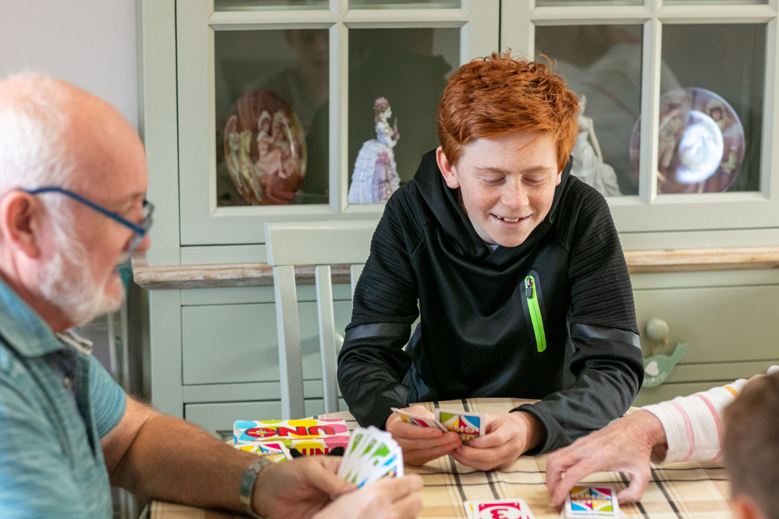 young boy playing cards and smiling